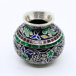May include: A small, round, decorative vase with a silver rim and a black body. The body is adorned with colorful floral and geometric patterns in green, blue, red, and yellow. The vase has a wide opening.