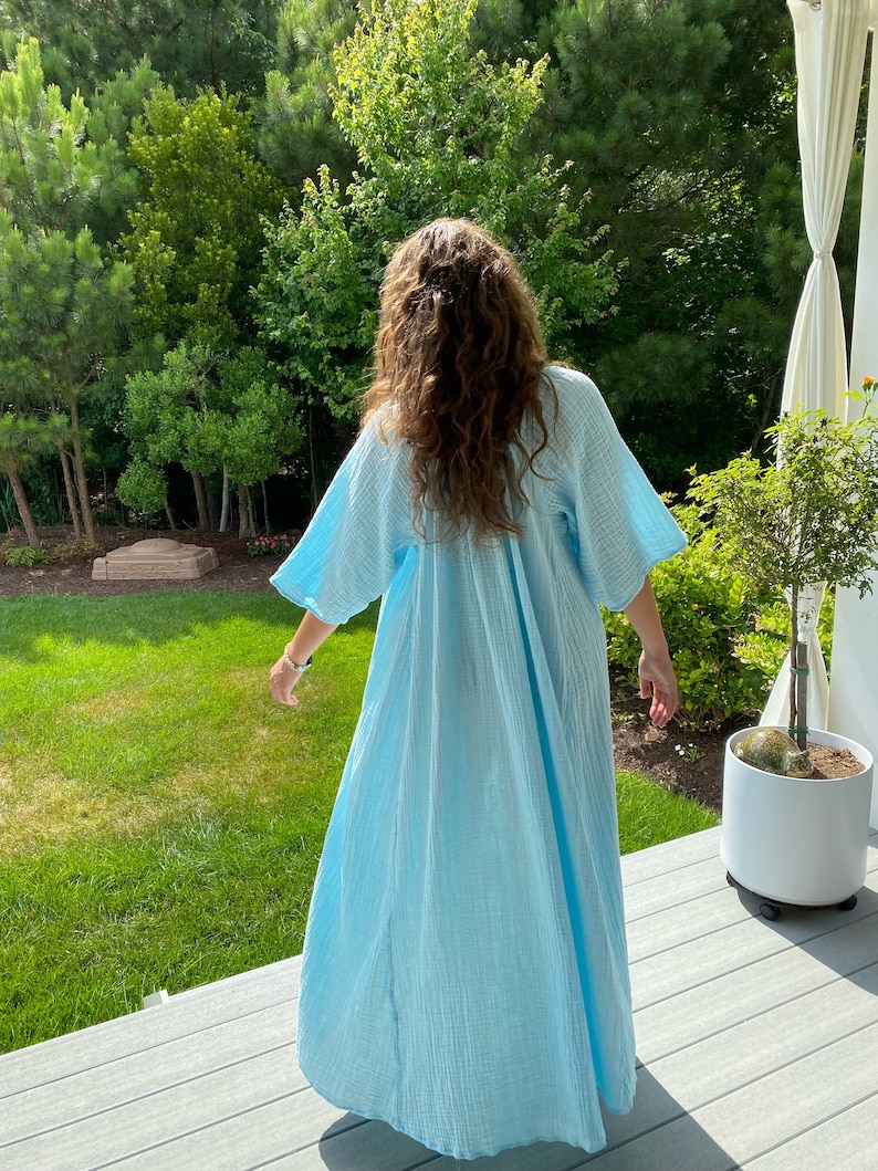 May include: A light blue, long, flowing, cotton dress with a loose fit and a V-neckline.