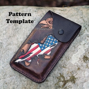 May include: A brown leather phone case with a distressed American flag design and an eagle head. The case has a flap with a snap closure.