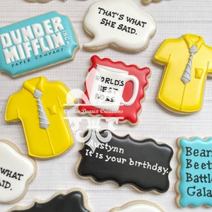 May include: A set of nine decorated sugar cookies featuring various designs and text. The cookies include a cookie with the text "Dunder Mifflin Paper Company", a cookie with the text "That's What She Said", a cookie with the text "World's Best Boss", a cookie with the text "Austynn It is your birthday", and a cookie with the text "I am Beyonce Always".
