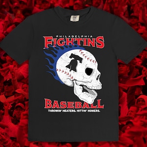May include: Black t-shirt with a white baseball skull graphic and the text "PHILADELPHIA FIGHTINS BASEBALL THROWIN' HEATERS, HITTIN' HOMERS."