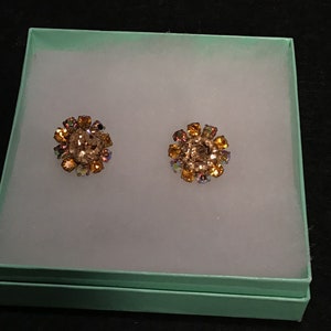 Vintage clip on earrings with alternating amber rhinestones and aurora borealis rhinestones, made in Austria.