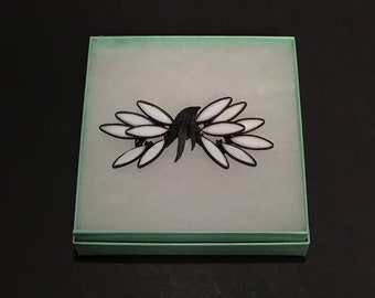 Mid-century vintage Corocraft brooch, black japanned metal and white milk glass elongated navettes, one petal missing.