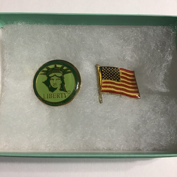 Duo of patriotic clutch pins, one hard enameled flag pin and one Liberty centennial commemorative pin (Weingeroff Enterprises).