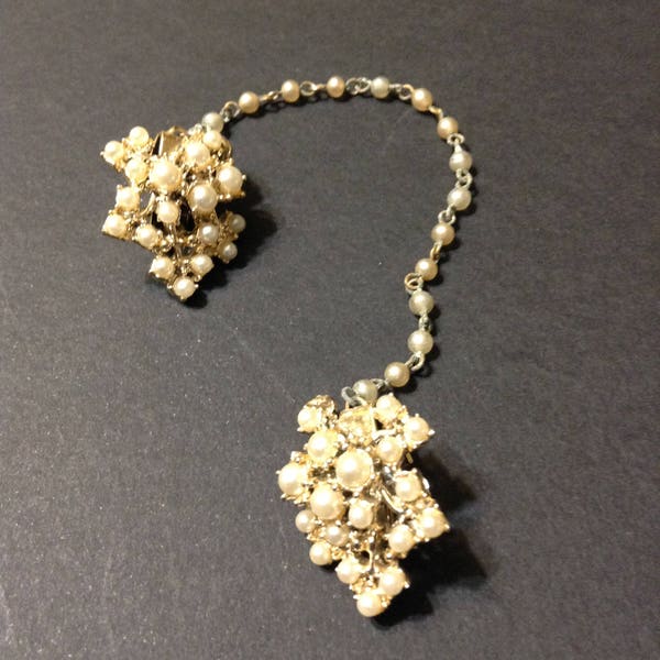 Vintage gold tone sweater clip with faux pearls on the leaf shapes and on the connecting chain.