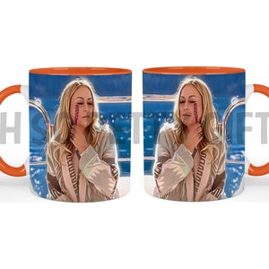 May include: A white ceramic mug with an orange rim features a colorful image of a woman with a pink object near her face. The background is a blurred image of a blue body of water and a railing.