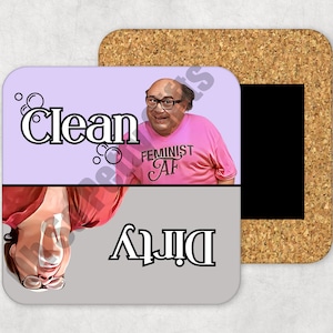 May include: A set of two cork coasters with a purple and gray design. One side features a man with a mustache wearing a pink shirt with the text "Feminist AF" and the word "Clean". The other side features a person upside down with the word "Dirty".