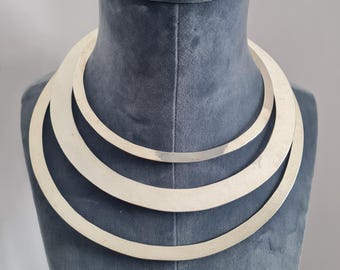 Op de afbeelding: Een zilveren chokerketting met drie overlappende cirkels.