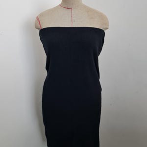 May include: A black strapless dress made of a ribbed knit fabric. The dress is fitted and has a straight skirt.