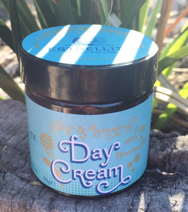 May include: A blue and gold jar of day cream with the text "Silky & Luxurious Day Cream with Resveratrol" on the label. The jar is 50g.
