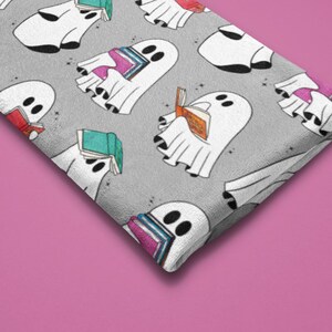 May include: A gray fabric with a repeating pattern of white ghosts reading books. The ghosts are in various poses, some sitting, some standing, and some floating. The books are colorful and have different titles.