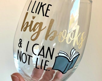 May include: A clear glass wine glass with a gold and black vinyl decal that reads "I like big books & I can not lie."  A blue and white illustration of an open book is next to the text.