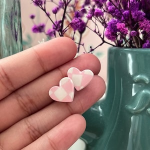 May include: A pair of pink and white gingham heart-shaped earrings.