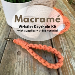 May include: Macrame Wristlet Keychain Kit with supplies + video tutorial. A close-up of a completed orange macrame wristlet keychain with a metal clasp.
