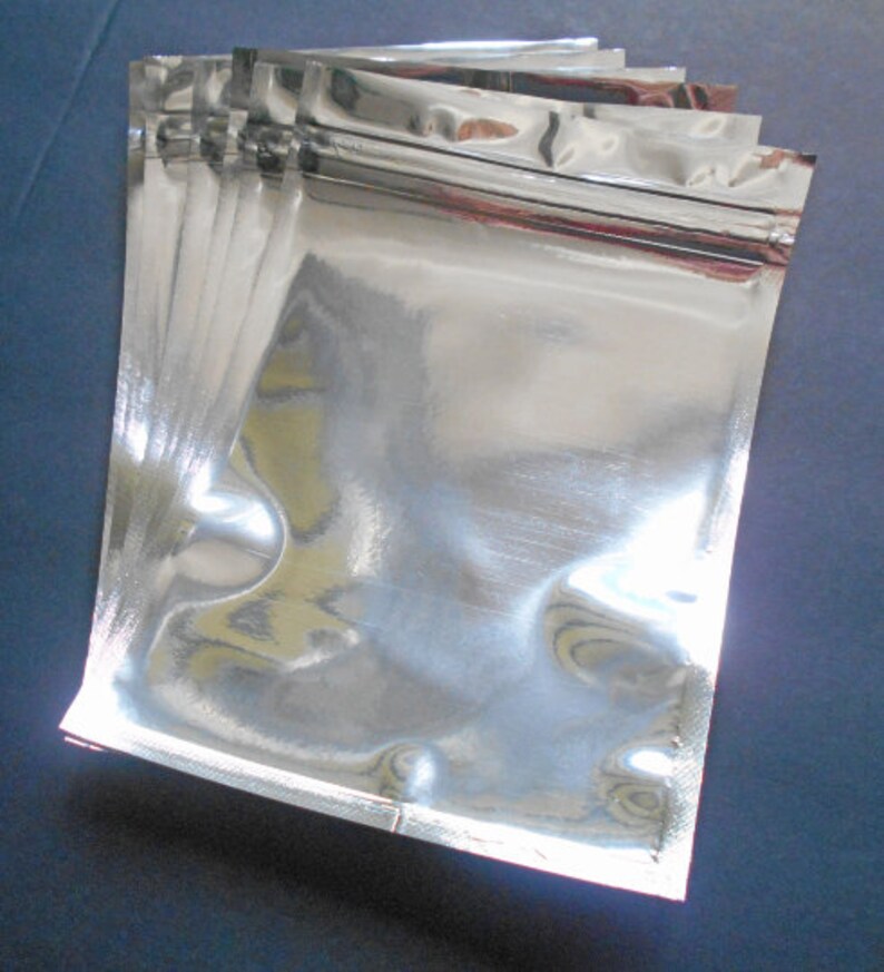 May include: A stack of silver foil zippered pouches, ideal for packaging small items.
