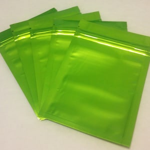 May include: A stack of five bright green resealable plastic bags with a zipper closure.