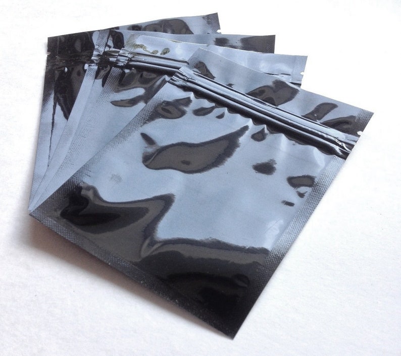 Pu&ograve; includere: Un set di cinque buste di plastica nere con chiusura a zip e una finitura trasparente e lucida.