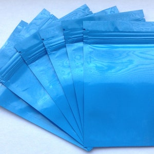 May include: A stack of six blue resealable plastic bags with a zipper closure.