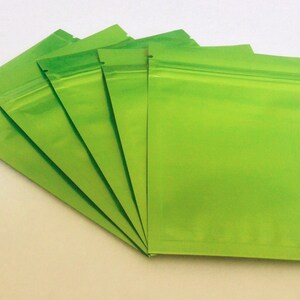 May include: Five green resealable plastic bags with a zipper closure.