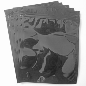 Pu&ograve; includere: Un pacchetto di cinque buste di plastica nere con chiusura a zip. Le buste sono trasparenti e hanno una finitura lucida.