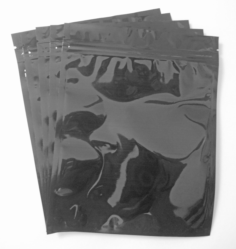 Pu&ograve; includere: Un pacchetto di cinque buste di plastica nere con chiusura a zip. Le buste sono trasparenti e hanno una finitura lucida.