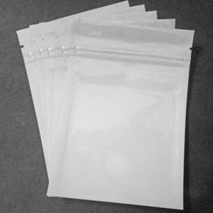 May include: A stack of five clear plastic resealable bags with a zipper closure.
