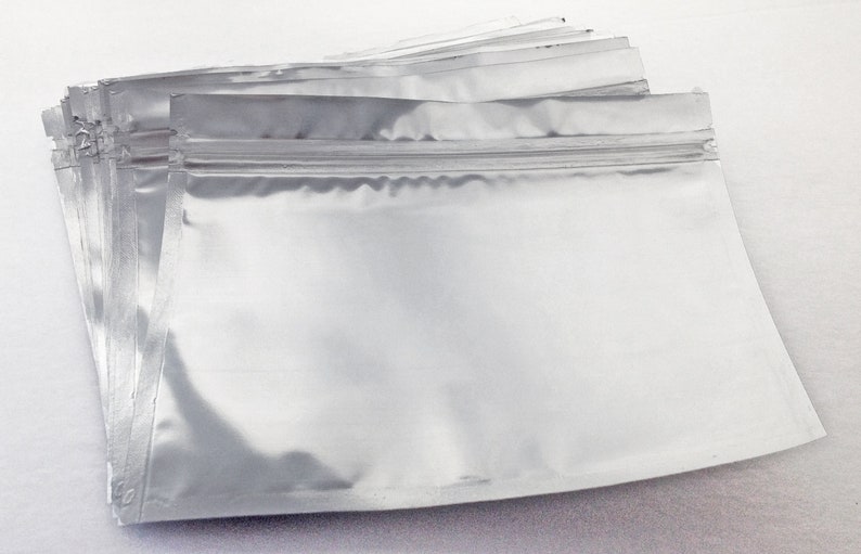 May include: A stack of silver foil zippered pouches, ideal for packaging small items.