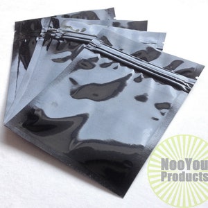 May include: A stack of five black plastic resealable bags with a zipper closure. The bags are clear and have a shiny finish.