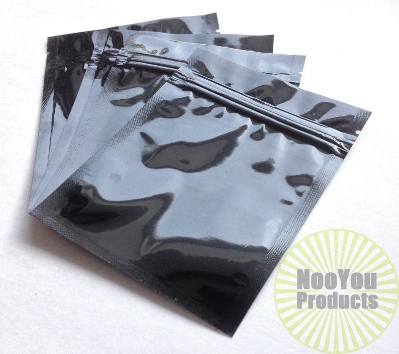 May include: A stack of five black plastic resealable bags with a zipper closure. The bags are clear and have a shiny finish.