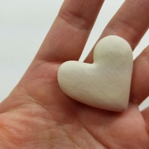 May include: A white ceramic heart-shaped ornament.