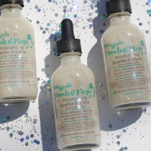May include: Three glass bottles with a white label and a green star design. The label reads "Fairy Blends Moondust Magic Moisturizing Sparkle & Shine with eco-friendly glitter". The bottles are filled with a clear liquid with glitter.