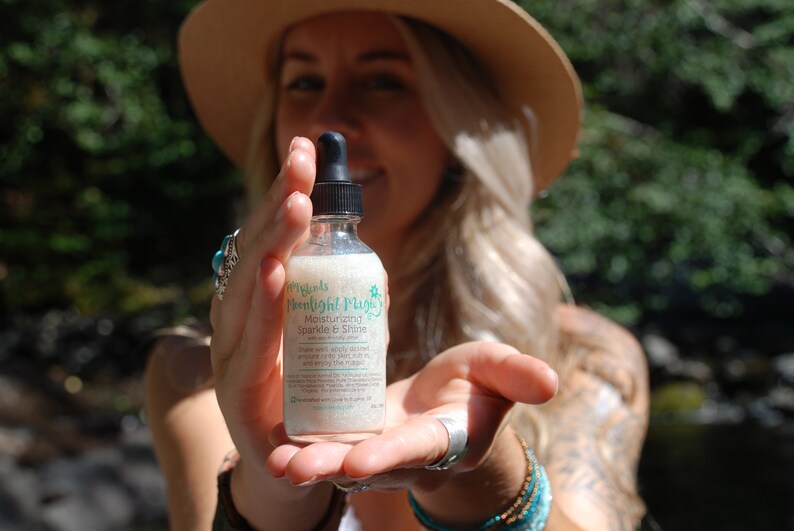 May include: A clear glass bottle with a dropper top, containing a white liquid. The bottle label reads "My Oils Moonlight Magic Moisturizing Sparkle & Shine".