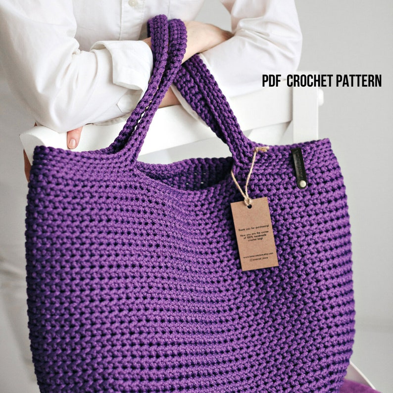 May include: Purple crochet tote bag with leather handles and a brown tag that says "Thank you for purchasing..."