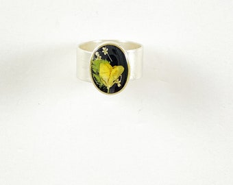 classic silver ring with yellow bird's foot trefoil flower and fern on black resin