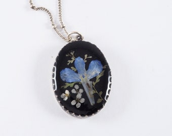 blue lobelia and white alyssum on black resin in silver oval necklace