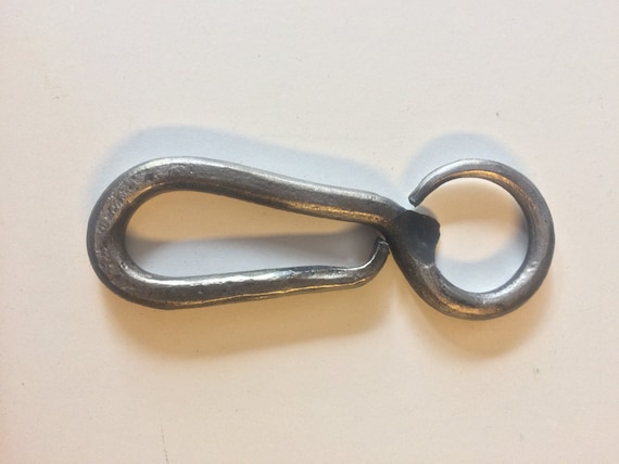 The highest-demand of the trio (18 ❤) — a blacksmith-made forged bottle opener that's proven its 'oh that's cool' pull with real buyers; raw iron texture and hand-hammered form make it look like it came out of a working forge, not a factory.