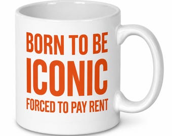 May include: A white ceramic mug with a handle on the right side. The front of the mug features the text "BORN TO BE ICONIC" in large orange capital letters, followed by the text "FORCED TO PAY RENT" in smaller orange capital letters.