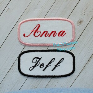 May include: Two embroidered name patches. One has a pink border with the name "Anna" in red script. The other has a black border with the name "Jeff" in black script. Both are rectangular with rounded corners.