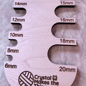 Pu&ograve; includere: Un misuratore di perline in legno con misure da 6 mm a 20 mm. Lo strumento &egrave; etichettato "BEAD SIZER" e include il testo "Crystal Makes the Things". Lo strumento &egrave; progettato per misurare le perline.