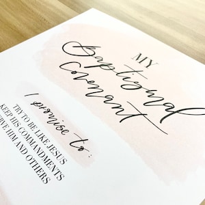 May include: A white card with pink watercolor accents and black text. The text reads "My Baptismal Covenant I promise to: Try to be like Jesus Keep His Commandments Serve Him and Others..."
