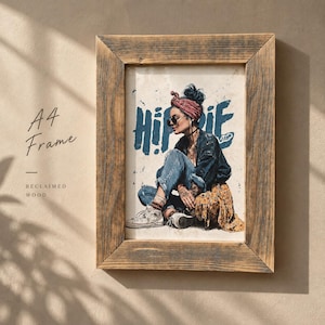 May include: A rectangular A4 reclaimed wood frame containing a print of a person wearing a red headscarf, sunglasses, a dark jacket, blue jeans, and white sneakers, sitting down. The word HIPPIE is printed in large blue letters behind the figure.