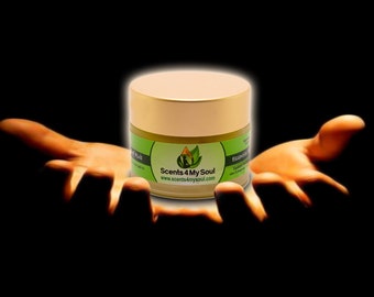 May include: A small, gold jar with a green label that reads "Scents 4 My Soul" and "www.scents4mysoul.com". The jar is sitting in the cupped hands of a person.