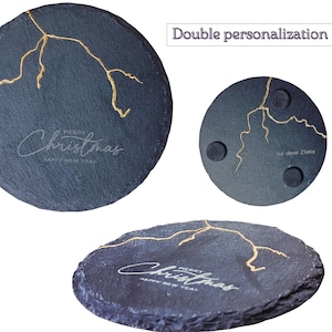 May include: Dark gray slate coasters with gold-colored vein-like accents. The coasters have the words "Merry Christmas" and "Happy New Year" etched on them. The image also shows the text "Double personalization".