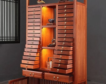 May include: A wooden cabinet with a glass top and multiple drawers. The cabinet has a light wood finish and is illuminated by lights inside. The cabinet has two doors on the bottom that are open.