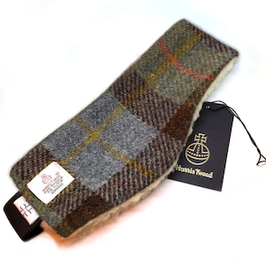 May include: A grey, brown and green plaid headband with a white fleece lining. The headband has a black strap with a small logo and a Harris Tweed label.