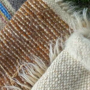May include: Two woven wool blankets with fringe. One blanket is brown and white, the other is white.