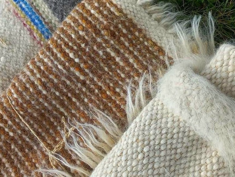 May include: Two woven wool blankets with fringe. One blanket is brown and white, the other is white.