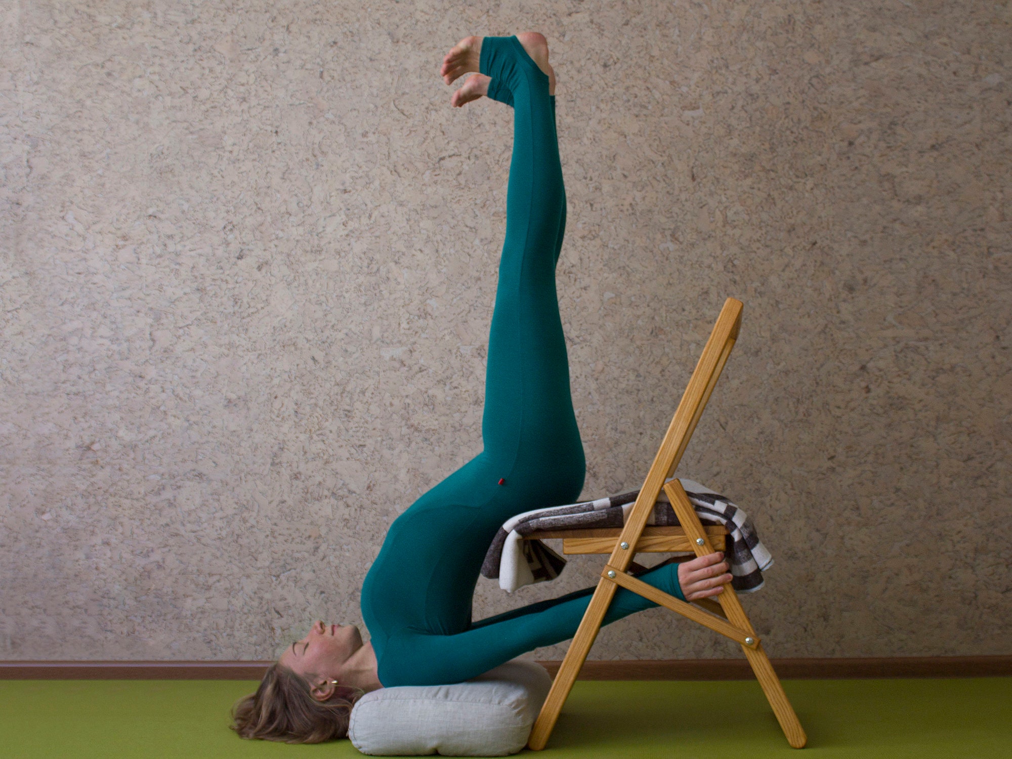 Yoga teacher practicing in studio with wooden walls and floor. Yogi using  chair for parsvottanasana pose. Iyengar yoga instructor with chair as prop  to help in posture, slow motion Stock Video Footage