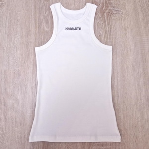 K&ouml;nnte beinhalten: Wei&szlig;es Tanktop mit dem Wort "NAMASTE" auf der Vorderseite.