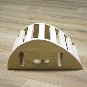 Peut inclure: Un plateau d'équilibre en bois avec une forme incurvée et plusieurs lattes. Le plateau est en bois clair et a une finition naturelle.